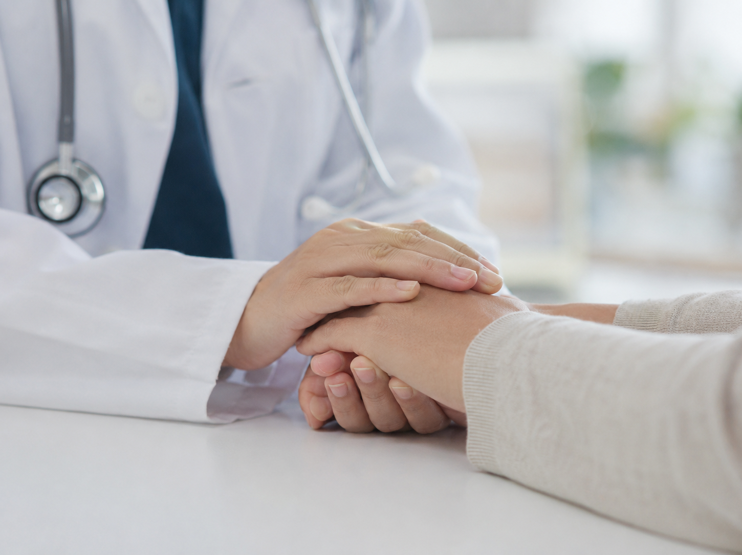 A doctor gently holding a patient's hands, offering reassurance